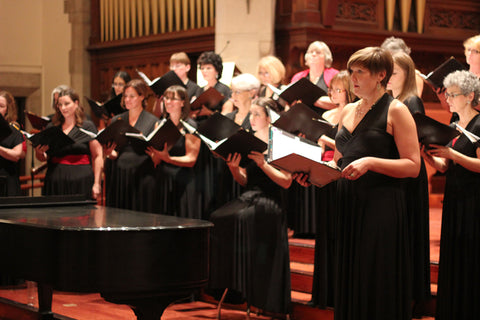 Oriana Women's Choir singing on stage, dressed in Henkaa's choir outfit