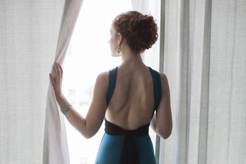 How to stop comparing yourself to others - confident woman looking out the window in a green dress