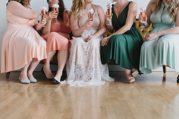 5 women raising glasses at a bridal party - add the party to the bridal checklist for your wedding day.