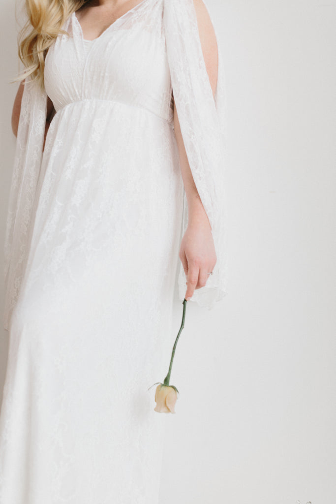 Bride wearing a Henkaa convertible wedding dress with white rose in her hand.