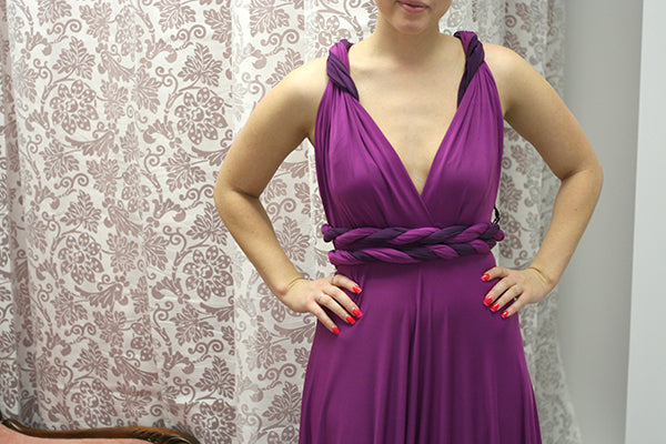 How to wear a sash: woman wearing a magenta purple dress and a sash as a twisted strap.