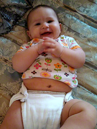 back folded down on large brown edge prefold diaper on a baby