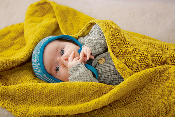 Disana kit blanket in curry on a baby