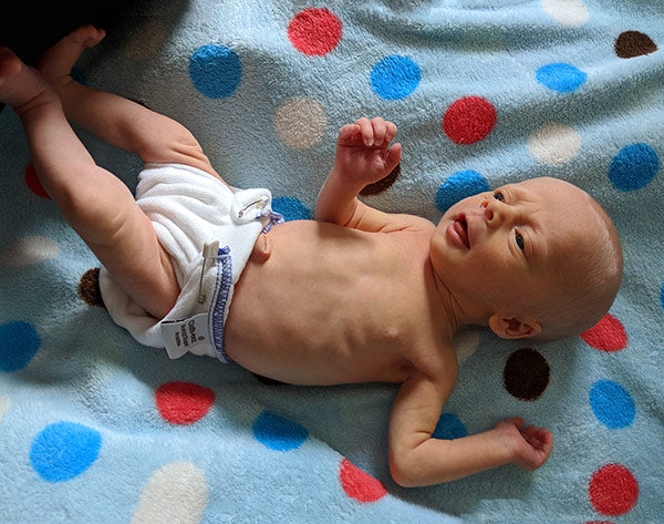 preemie baby in a prefold cloth diapers 4 and a half pounds