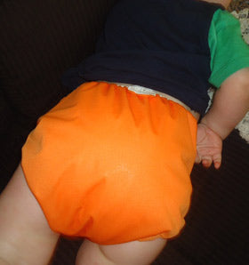 large tangerine pull on diaper cover on baby
