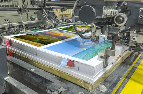offset machine press print run at table, sheet-fed paper feeder unit. Poster printing