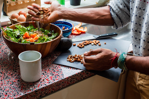 A person preparing a bowl of salad