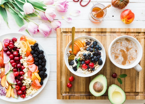 A table of smoothie bowls, honey, and fruit