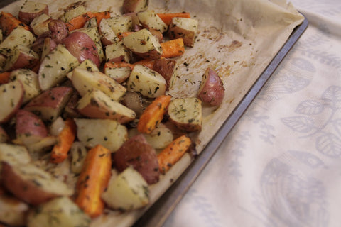 sliced baked potatoes with herbs on a tray