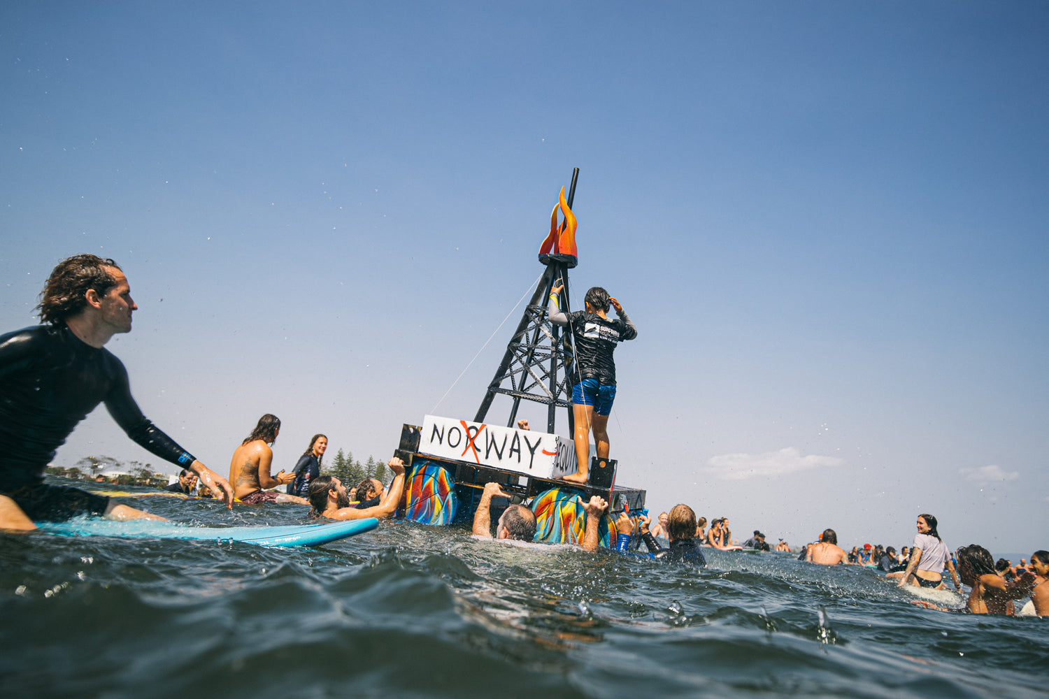 Byron Bay surfers rally around a replica oil rig. 