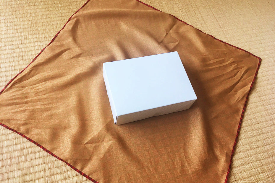 Place the Furoshiki face down and put the gift box in the middle at an angle.