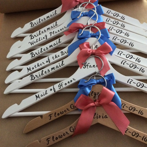 wooden hangers with personalised wording finished with blue and pink bows