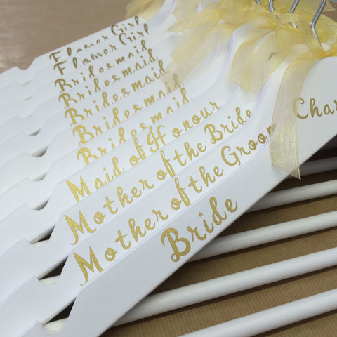 White hangers with gold writing and gold bow