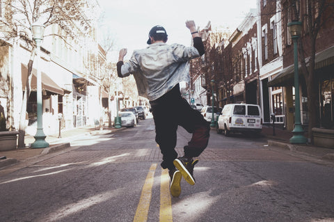 A man jumping in the middle of the street.