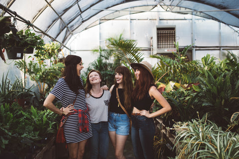 A group of happy women talking around plants.