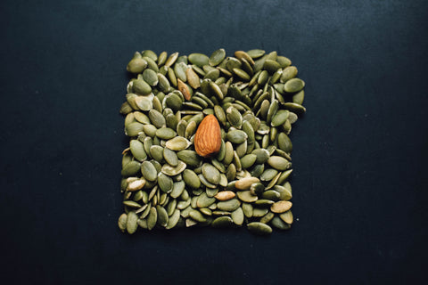 Some pumpkin seeds and an almond.