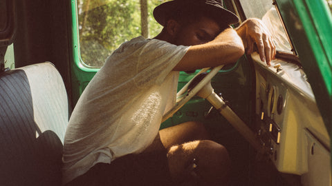 A tired man in a retro car.