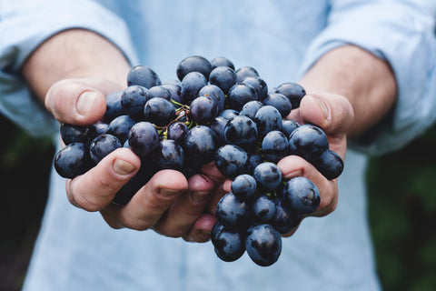 Holding grapes.