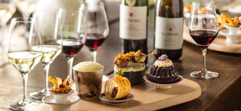 Wine and food tasting platter with red and white wine on a wooden table