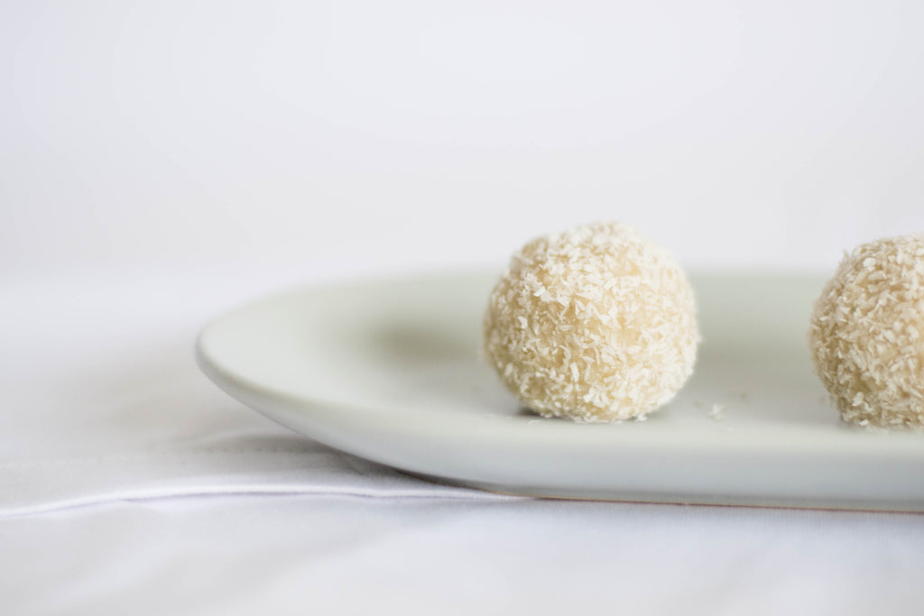 ShortHive salted (caramel) honey bliss balls recipe. Image showing ready bliss balls on white plate.