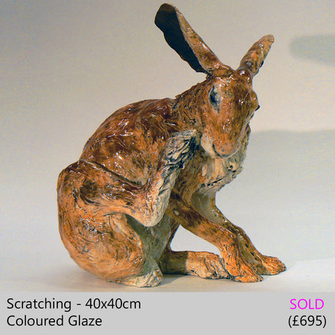 sculpture of a hare having a scratch, ceramic, raku animal sculpture