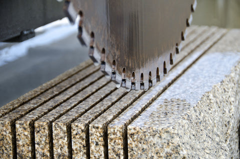 a circular saw cuts multiple parallel lines into granite
