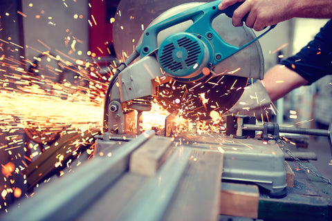 A circular saw being used to cut metal, sending sparks everywhere