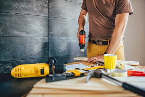 Man using power drill on a piece of wood