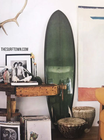 Tabla de surf verde decorando un salon estilo boho