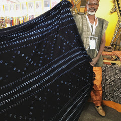 Thread Spun fair trade artisan from Burkina Faso showing off his naturally and hand-dyed, handmade textiles for sale.