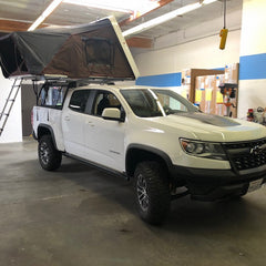 white Chevy Colorado with iKamper Skycamp 4x v2 Roof Top Tent installed on Leitner Truck Bed Rack at Rhino Adventure Gear California