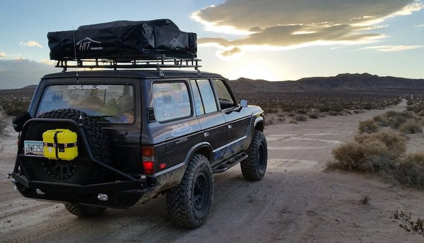 Overland vehicle outfitted with yellow off road first aid kit mounted to back of rig