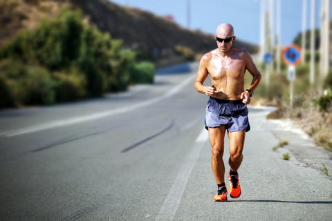 shirtless bald man running cross country