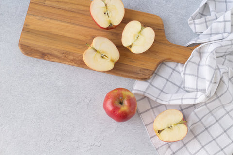 apples cut in half on a wooden cutting board