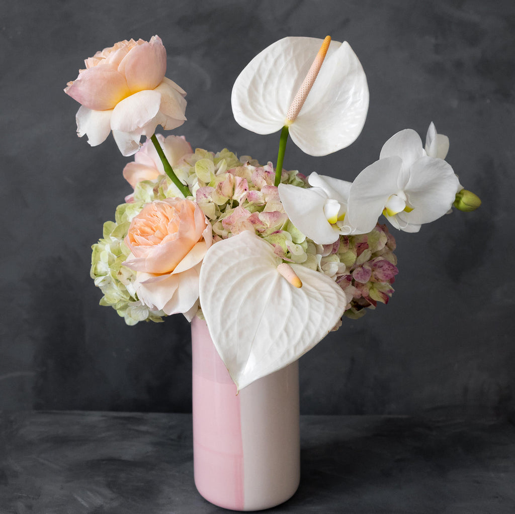 Vased floral arrangement in a pink vase with orchids and roses. Rochester Ny florist | Florist Rochester NY