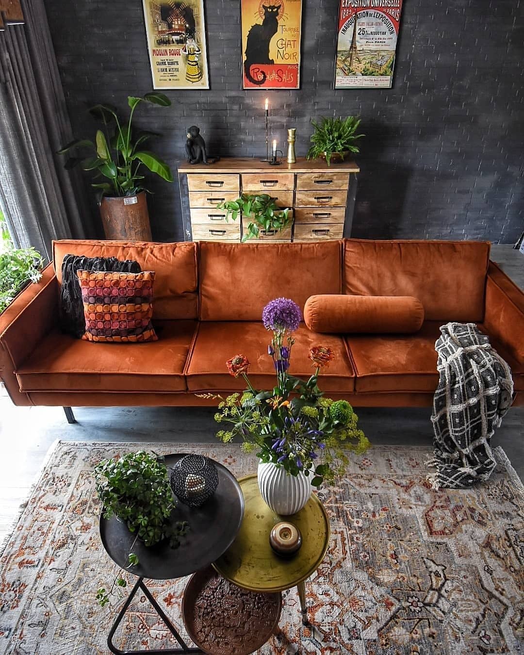 Warm rust sofa in an eclectic living room and metal drapery rods