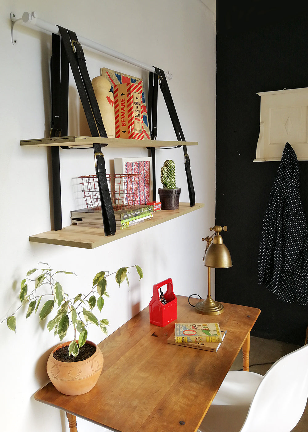 hanging shelf in home office with small wooden desk and pot plant