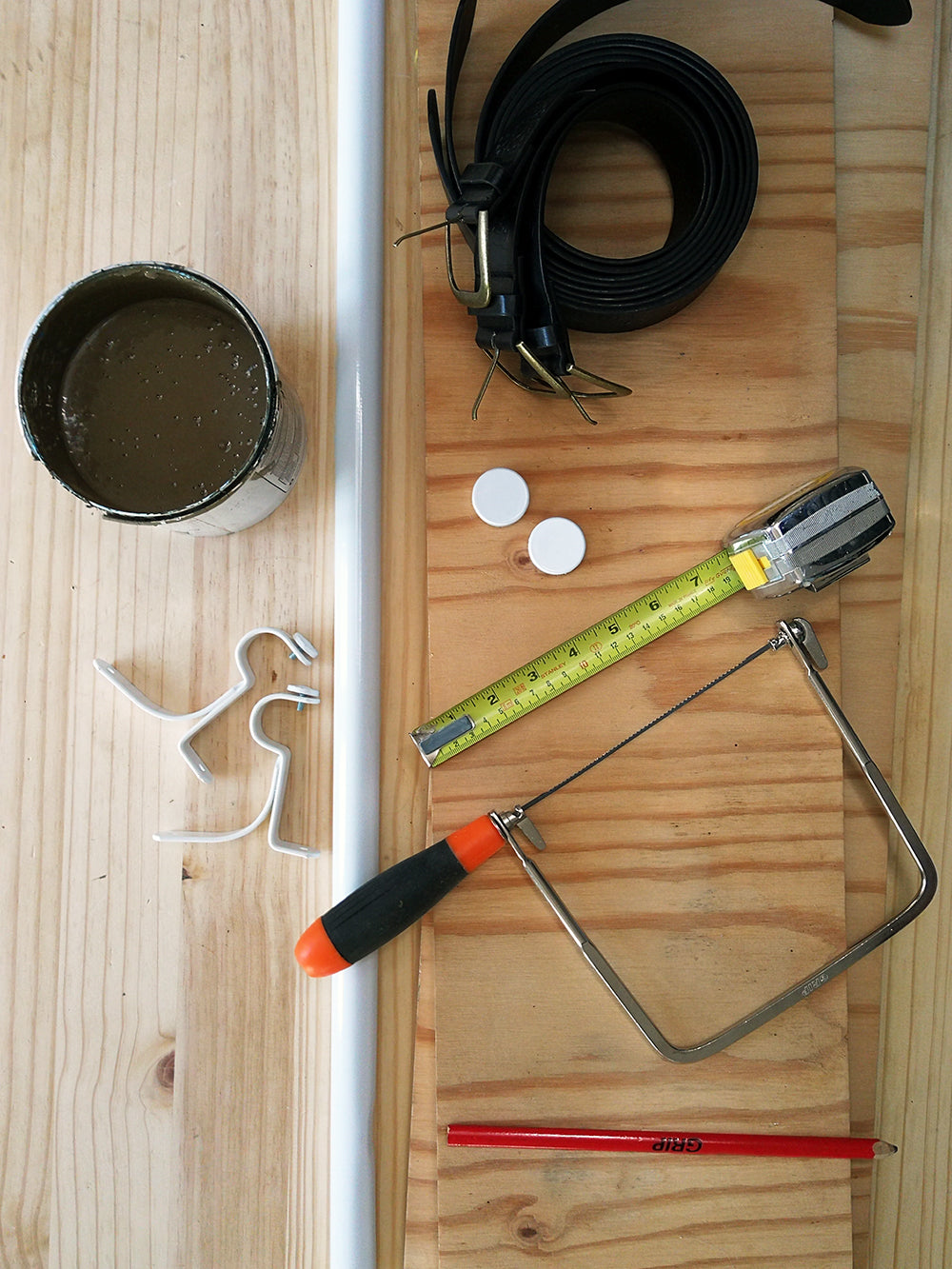 diy hanging shelf materials, including jigsaw, belts, measuring tape, pencil, curtain brackets and plywood
