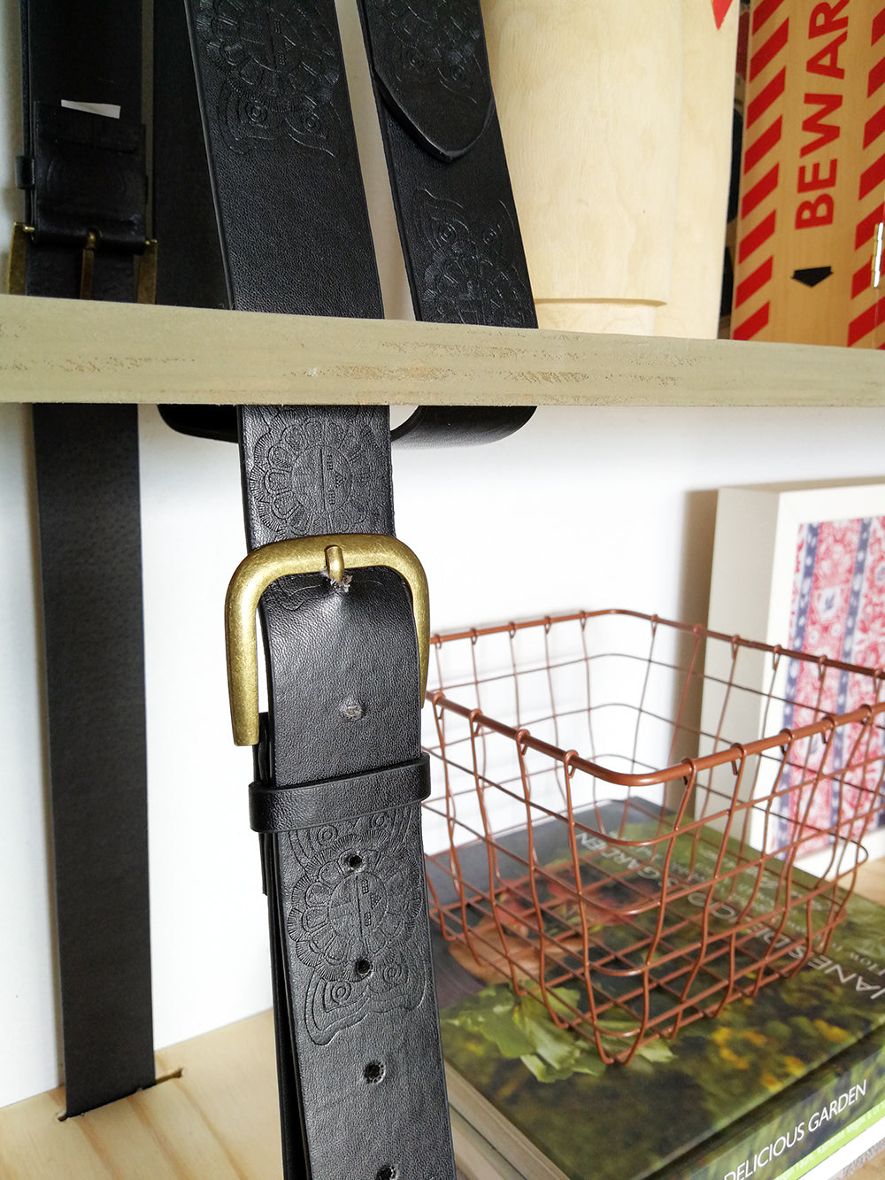 close up of black belt of home made hanging shelf