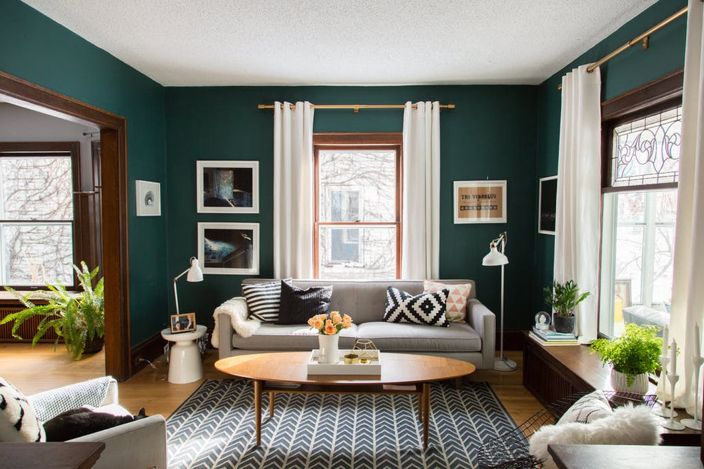 living room with green walls and golden curtain rods