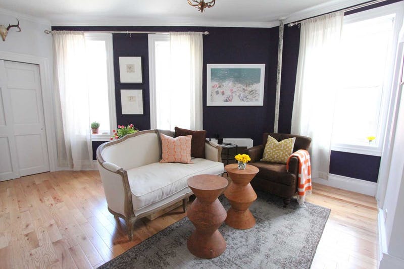 modern living room with dark walls wooden floors and chrome curtain finishes