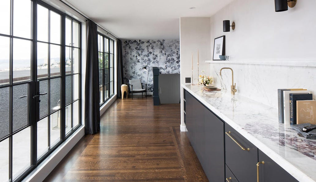 modern minimalist kitchen area with wood flooring and black curtains