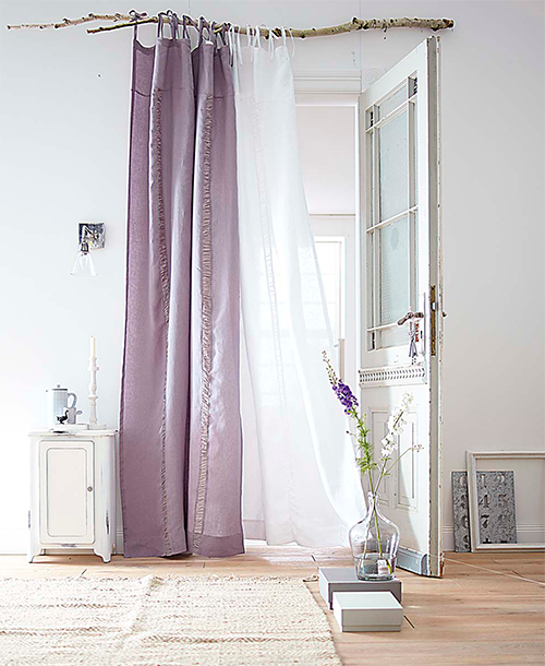 rustic minimalist pink and white curtains suspended by a natural wood branch as curtain rod
