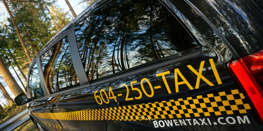 Side image of Bowen Land taxi parked in front of a wooded park.