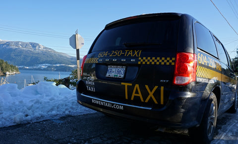 Back view of taxi with snow, water and mountains in the background 