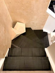 Padding on stairs under a home climbing wall installed in a stairwell