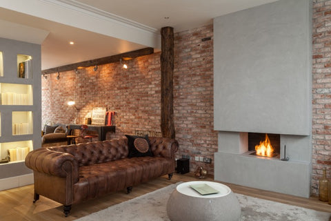 gorgeous brown chesterfield sofa next to fireplace