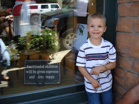 little boy in front of sign