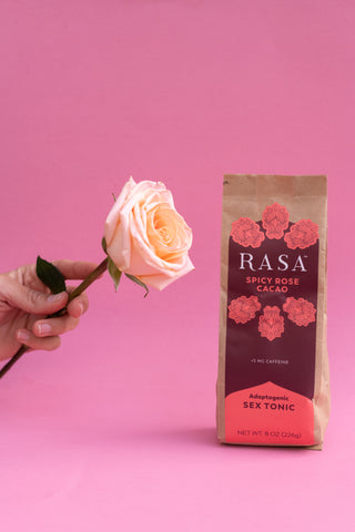 Hand holding rose and bag of Aphrodisiac Spicy Rose Cacao Rasa