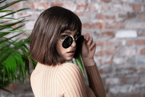 Women wearing vintage round wood sunglasses with gold metal